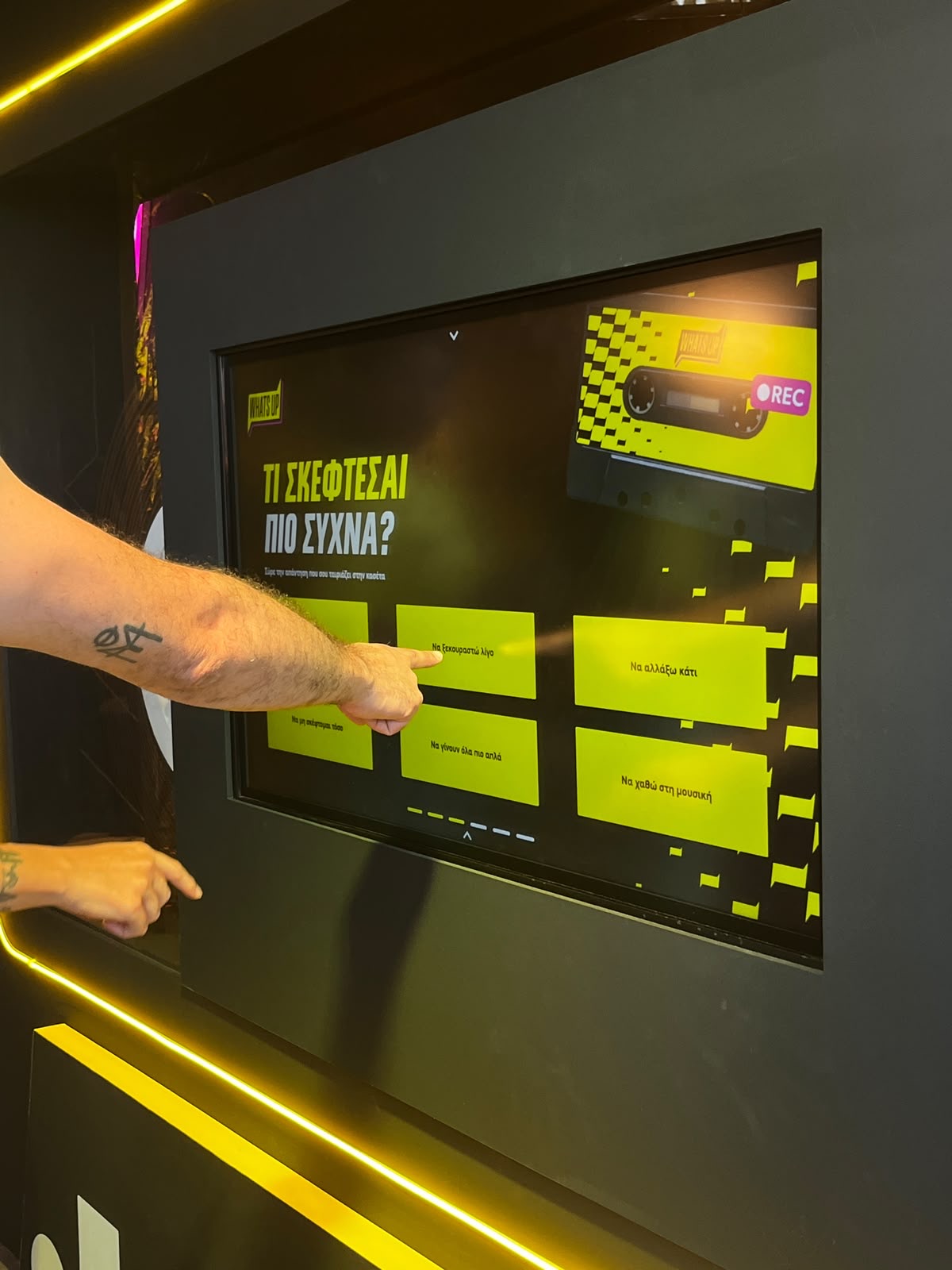 Hand pointing at a question on the cassette touchscreen